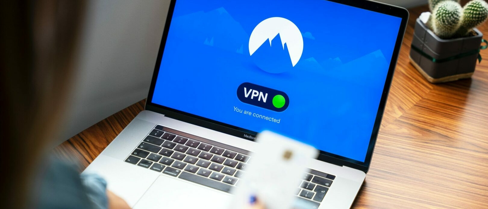 image d'un ordinateur portable. A l'écran est affiché un VPN sur fond bleu.