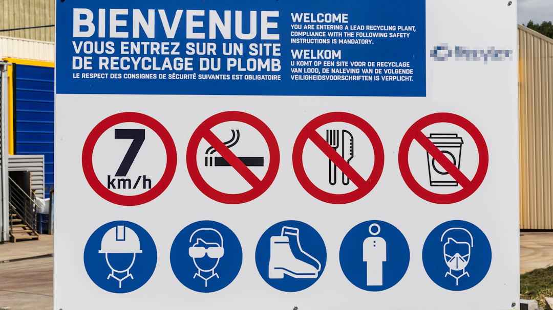 Photo d'un panneau à l'entrée d'un centre de recylcage de plomb indiquant les règles à respecteret les EPI à porter. Les centres de recyclage sont la place centrale du suivi des bennes.